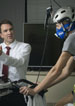 man on stationary bike who is being tested for asthma with breathing mask on